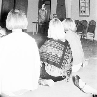 People attending a traditional cultural performance indoors.