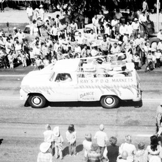 Vintage parade truck with crowd watching.