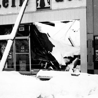 Heavy snow damage to storefront and signage.