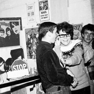Punk rock exhibition or event with posters and attendees.