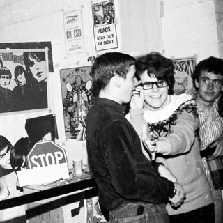 Punk rock exhibition or event with posters and attendees.
