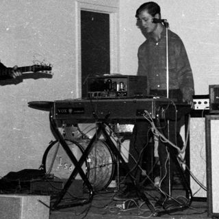 Band performing live with guitars, keyboard, and vocals.