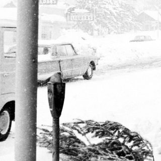 Snowy street scene with people walking under shelter.
