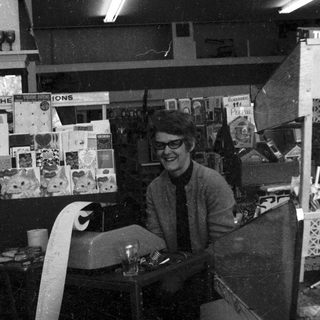 Vintage record store owner behind counter.