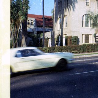 Historic hotel building with vintage cars.