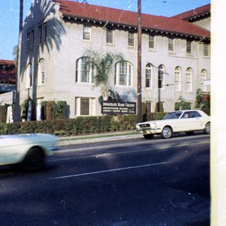 Historic hotel building with vintage cars.