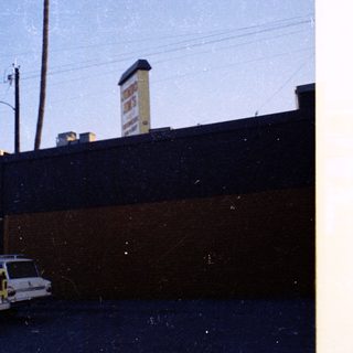 Vintage station wagon parked near industrial building.