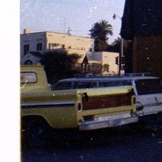 Vintage station wagon parked near industrial building.