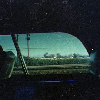 Vintage car view through rain-streaked windshield.