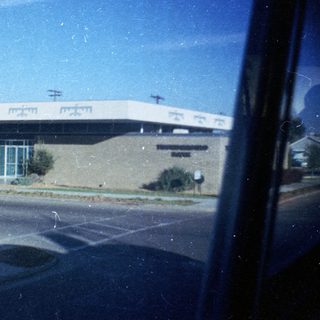 Large building viewed through car window.