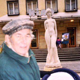 Man taking selfie with mannequin in indoor setting.