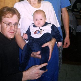 Family portrait with grandparents, parents, and baby.