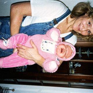 Woman holding pink teddy bear doll.