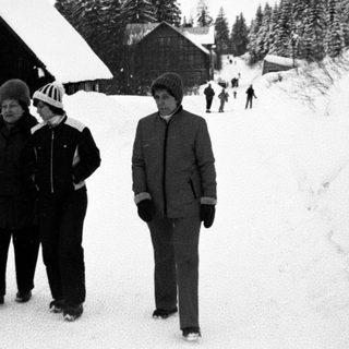 Family posing in snowy mountain village.