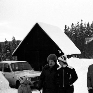 Family posing in snowy mountain village.