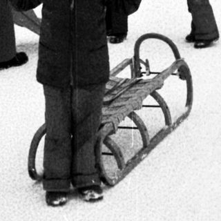 People sledding on snow-covered hill.