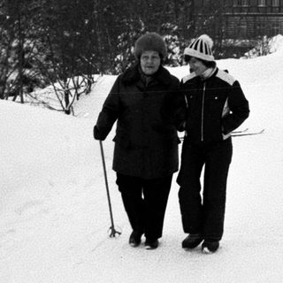 Two people skiing on snow-covered trail.