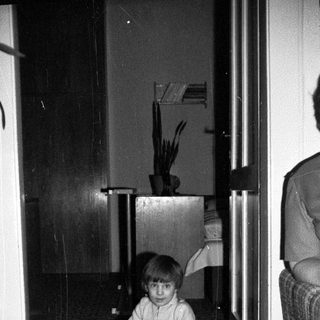 Child playing with toy on tiled floor indoors.