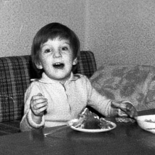 Older man and young child sharing a meal indoors.