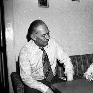 Older man and young child sharing a quiet moment indoors.
