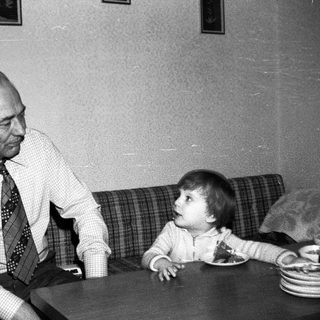Older man and young child sharing a quiet moment indoors.