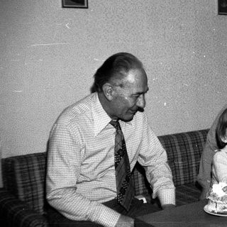 Family celebrating birthday with cake indoors.