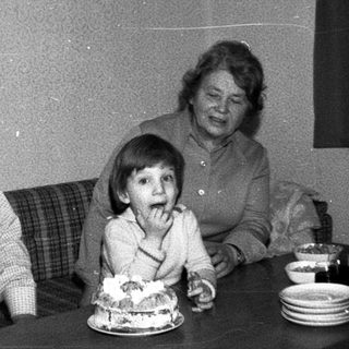 Family celebrating birthday with cake indoors.