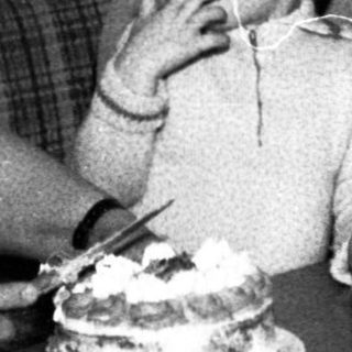 Family sharing cake indoors during a gathering.