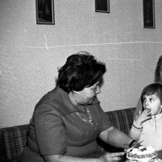 Family sharing cake indoors during a gathering.