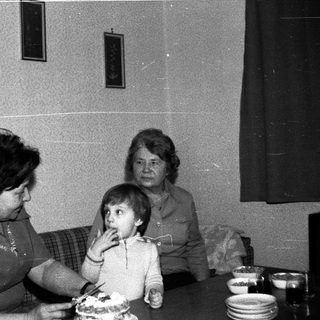 Family sharing cake indoors during a gathering.