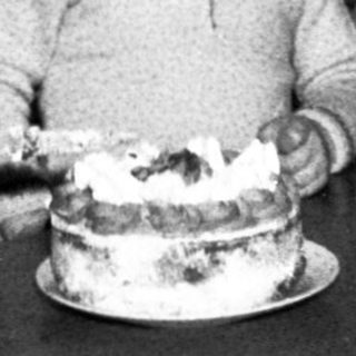 Family sharing birthday cake indoors.
