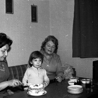 Family sharing birthday cake indoors.