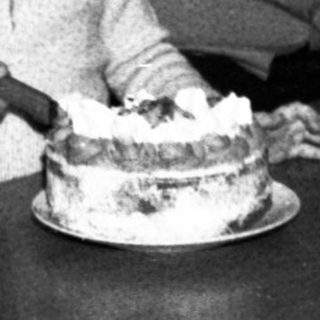Family sharing birthday cake indoors.