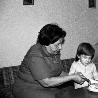 Family sharing birthday cake indoors.