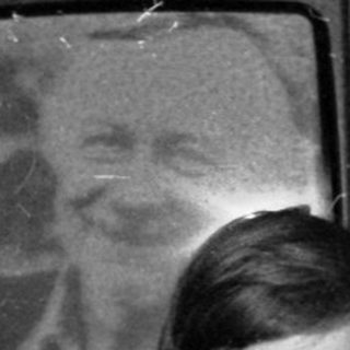 A woman and young boy posing indoors near old TV.