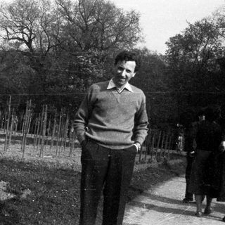 Man standing outdoors in a garden area.