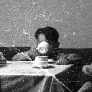 Family meal scene in vintage indoor setting.