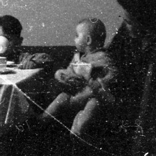 Family meal scene in vintage indoor setting.