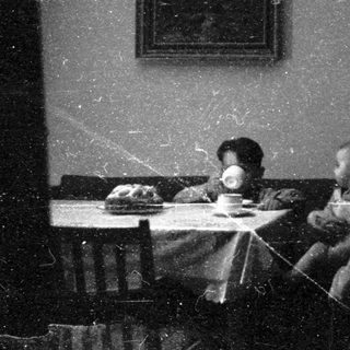 Family meal scene in vintage indoor setting.