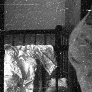 A man and child sitting closely indoors.