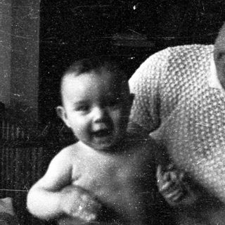 A woman holding a smiling infant indoors.