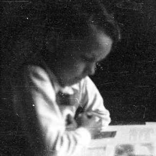 A person sitting at a desk writing.