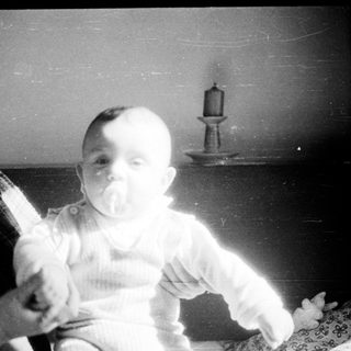 A woman holding a baby indoors.
