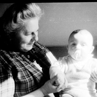 A woman holding a baby indoors.