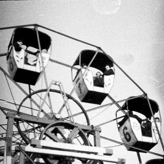 Ferris wheel gondolas with people inside.