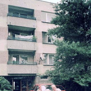 Family posing outside residential building with wheelchair.