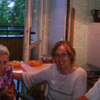 Four people smiling indoors near open window.