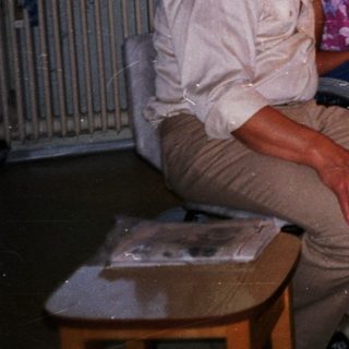 Four elderly people smiling together indoors.