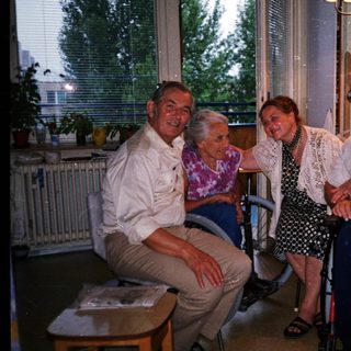 Four elderly people smiling together indoors.