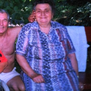 Four adults posing together outdoors in casual attire.